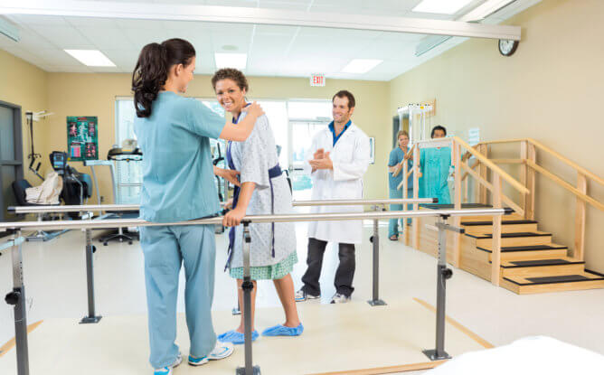 A nurse supports a patient with a walker, providing care and assistance in a clinical environment